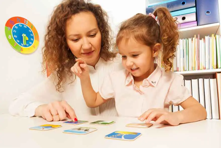 Parent using picture cards to teach an autistic child emotions